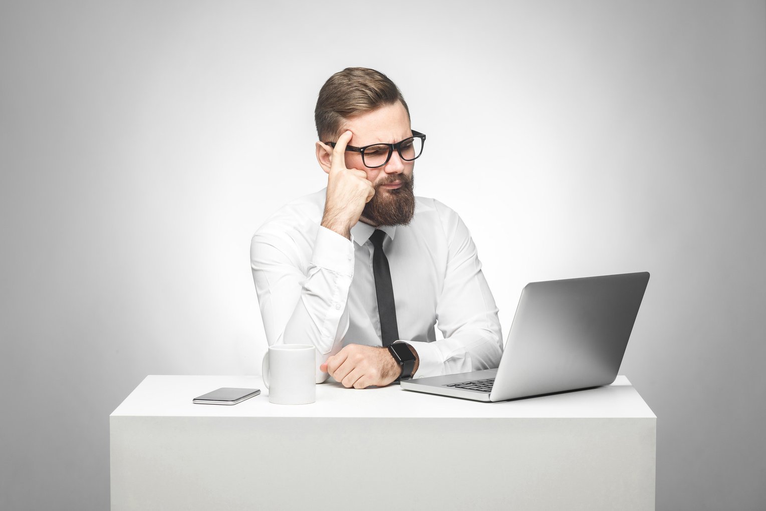 Pensive Businessman Looking at a Laptop on the Table